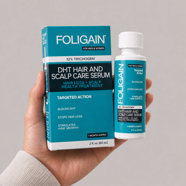 Hand holding the FOLIGAIN DHT Hair and Scalp Care Serum bottle and box, 60 mL.