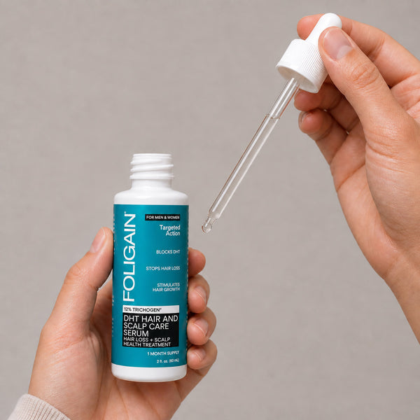 Hands holding an open FOLIGAIN DHT Hair and Scalp Care Serum bottle and a dropper with serum.